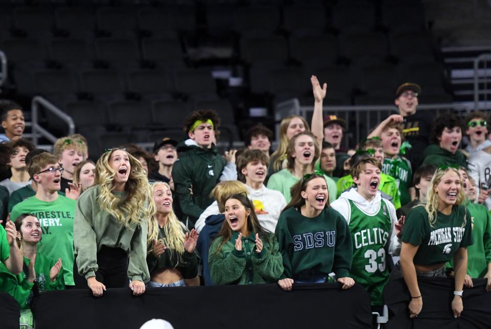 Harrisburg fans, dressed in green for St. Patrick's Day, cheer from the stands in the first round of the high school boys state basketball tournament on Thursday, March 17, 2022, at the the Denny Sanford Premier Center in Sioux Falls.