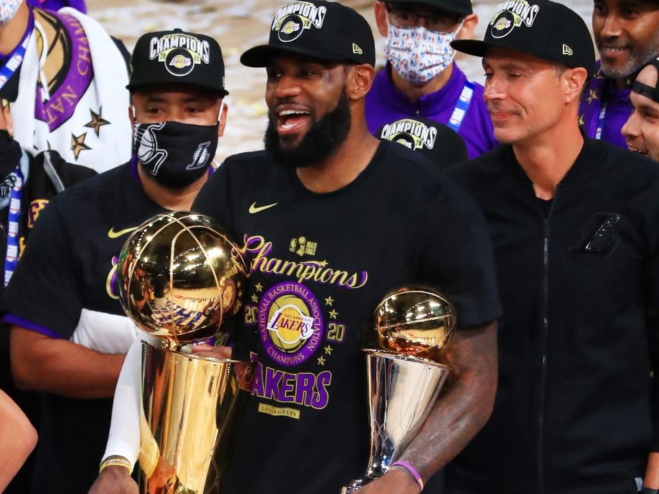 LeBron James #23 of the Los Angeles Lakers reacts with his MVP trophy and Finals trophy after winning the 2020 NBA Championship over the Miami Heat in Game Six of the 2020 NBA Finals