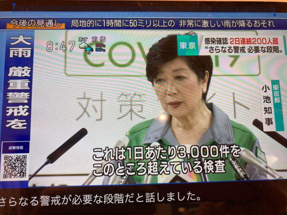 小池每天穿戰鬥服開記者會演出防疫，強調是因為篩檢件數多才會確診多。   圖：攝自NHK