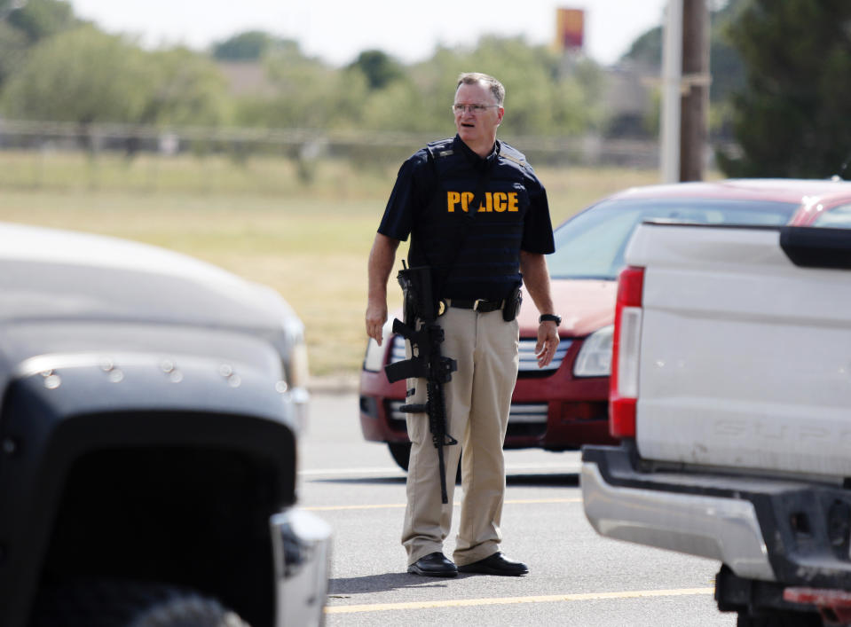 A law enforcement officer stands in the middle of the 5100 block of E. 42nd Street in Odessa, Texas, Saturday, Aug. 31, 2019, following a shooting at random in the area of Odessa and Midland. Several people were dead after a gunman who hijacked a postal service vehicle in West Texas shot more than 20 people, authorities said Saturday. The gunman was killed and a few law enforcement officers were among the injured. (Mark Rogers/Odessa American via AP)