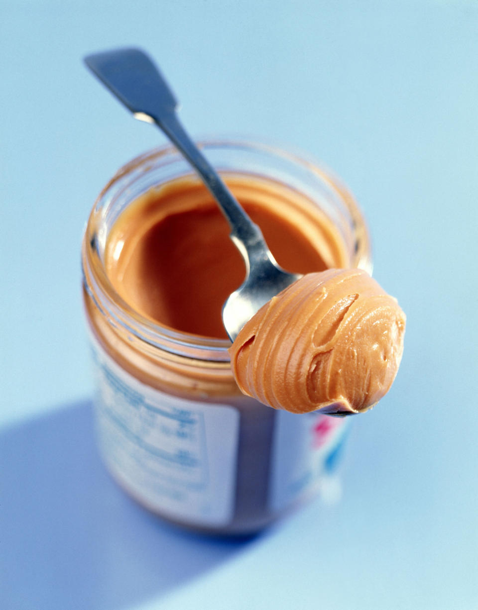 Peanut butter on a spoon in a jar