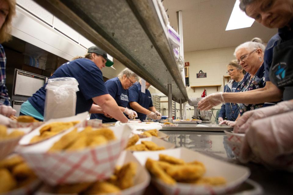 Staff portion food into boats while preparing a meal at Springfield School District’s respite center at Springfield High School as winter storm recovery gets underway on Jan. 18 in Springfield.