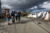 <p>Residents carry water and MREs received from FEMA about two weeks after Hurricane Maria swept through the island on Oct. 5, 2017 in San Isidro, Puerto Rico. Residents in their section of the town remain without grid power or running water although a few have been able to acquire generators for power. (Photo: Mario Tama/Getty Images) </p>