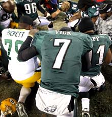 Michael Vick, teammates and players of the Packers pray together after the game