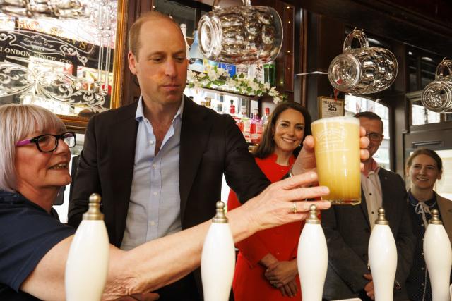 Britain's Prince William pulls the first pint of Kingmaker, a new brew celebrating the coronation of King Charles III, as he and the Princess of Wales visit the Dog & Duck pub in London, Thursday, May 4, 2023, to hear how it's preparing for the coronation of King Charles III and the Queen Consort at the weekend. (Jamie Lorriman/Pool Photo via AP)