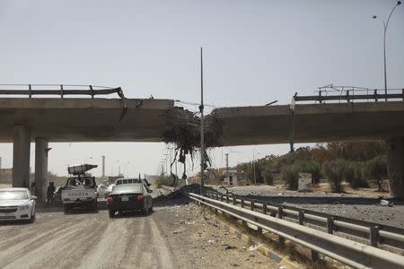 A general view of the damage of the 27th Bridge is seen along a road linking Tripoli and the western Libyan cities, near a former Libyan Army camp known as Camp 27 following clashes between rival militias in the 27 district, west of Tripoli, August 22,2014. REUTERS/Stringer