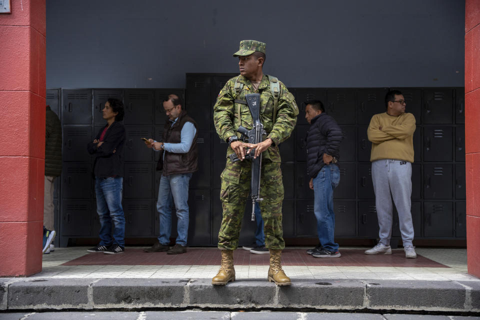 A soldier guards a polling station during a snap election in Quito, Ecuador, Sunday, Aug. 20, 2023. The special election was called after President Guillermo Lasso dissolved the National Assembly by decree in May to avoid being impeached.(AP Photo/Carlos Noriega)
