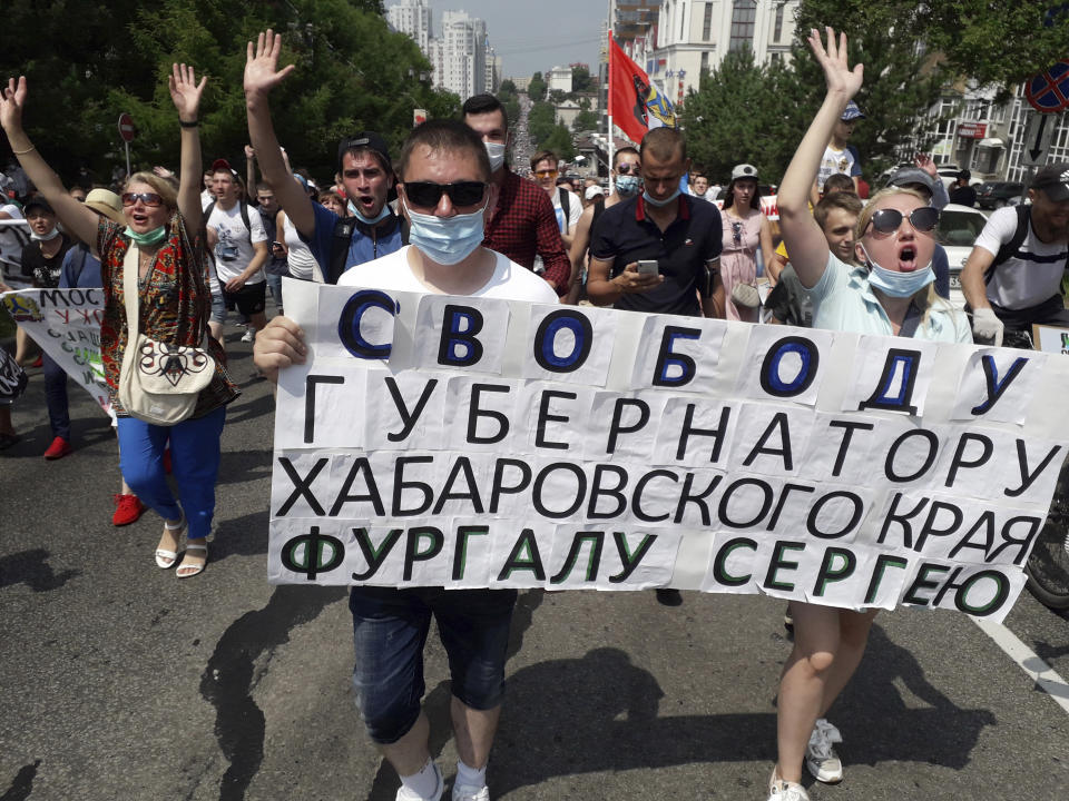 People hold posters reading "Freedom for Khabarovsk region's governor Sergei Furgal" during an unsanctioned protest in support of Furgal, who was interrogated ordered held in jail for two months, in Khabarovsk, 6,100 kilometers (3,800 miles) east of Moscow, Russia, Saturday, July 18, 2020. Thousands of demonstrators in the Russian Far East city of Khabarovsk gather to protest against the arrest of the region's governor on charges of involvement in multiple murders. (AP Photo/Igor Volkov)