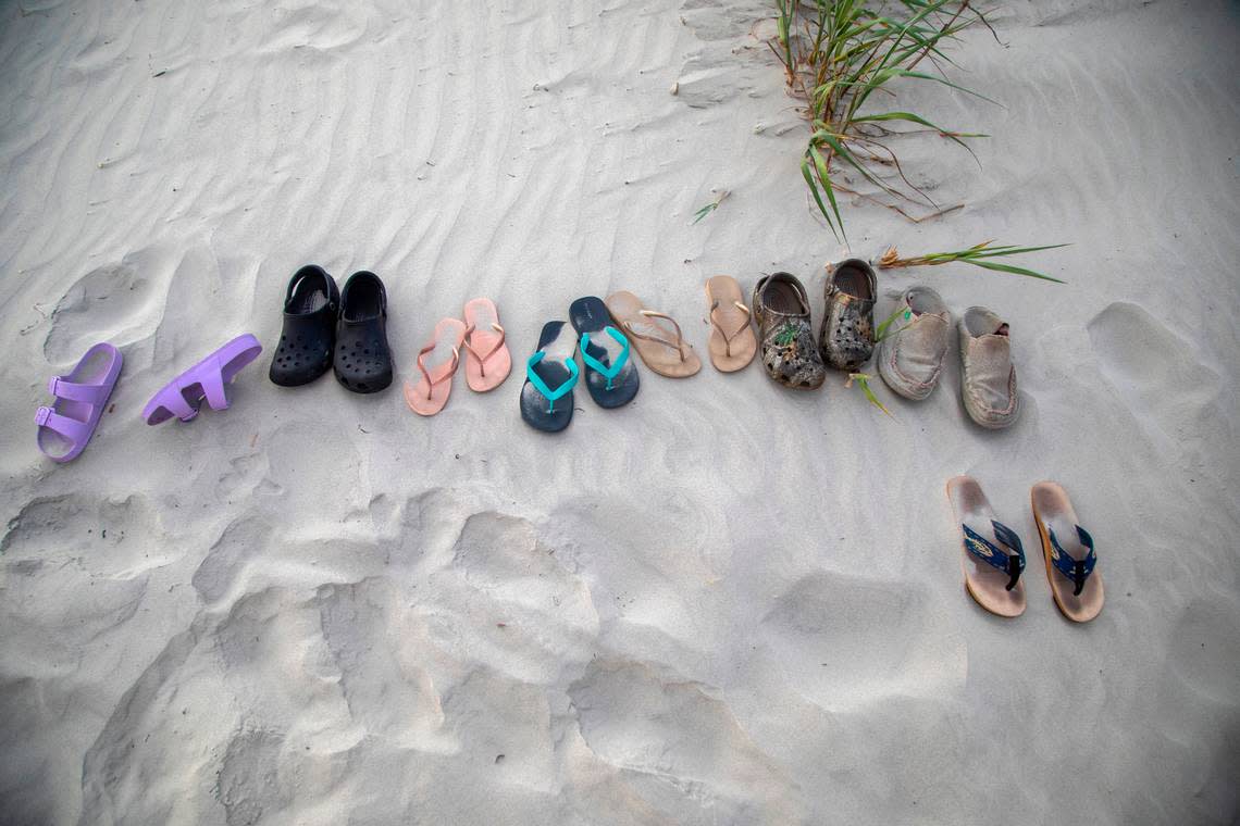 Shoes and sandals lie in the sand on Sunset Beach in June 2022. Travis Long/tlong@newsobserver.com