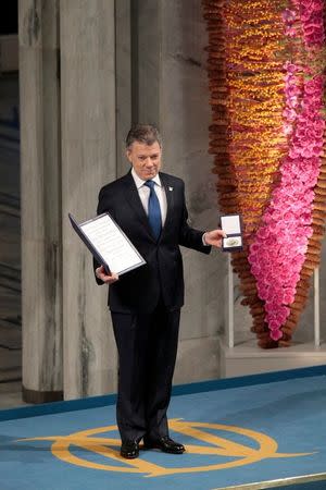 Nobel Peace Prize laureate Colombian President Juan Manuel Santos poses with the medal and diploma during the Peace Prize awarding ceremony at the City Hall in Oslo, Norway December 10, 2016. NTB Scanpix/Lise Aaserud/via REUTERS