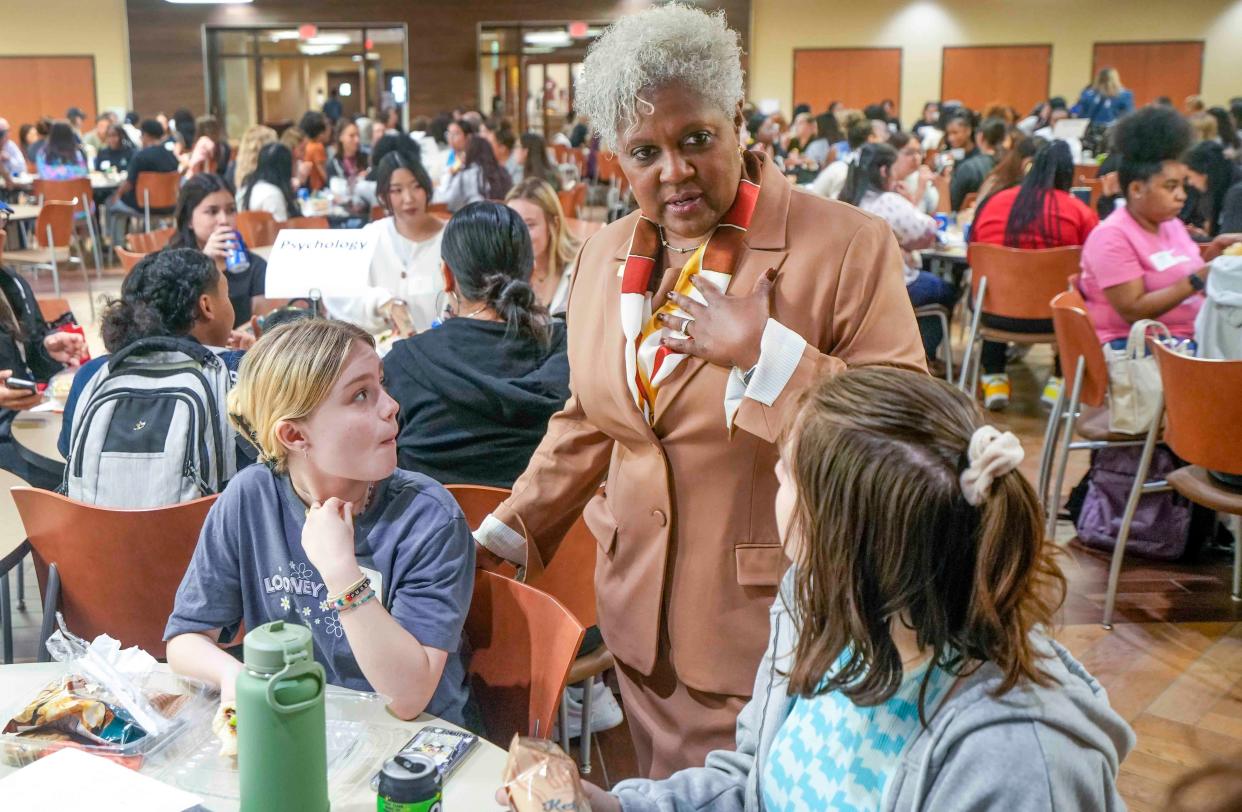 Alverno College's new president, Christy Brown, talks with River Henkel, left, and Brooke Salomone, on Aug. 28, after a convocation ceremony. Henkel and Salomone are both majoring in psychology.