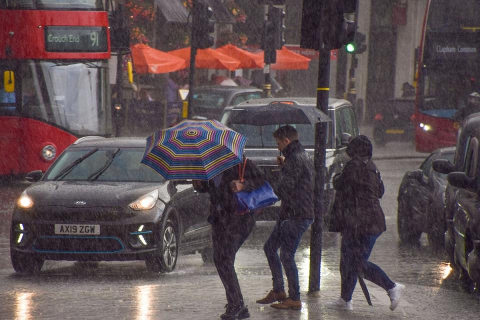 File photo: People try to stay out of the rain in London (Getty Images)