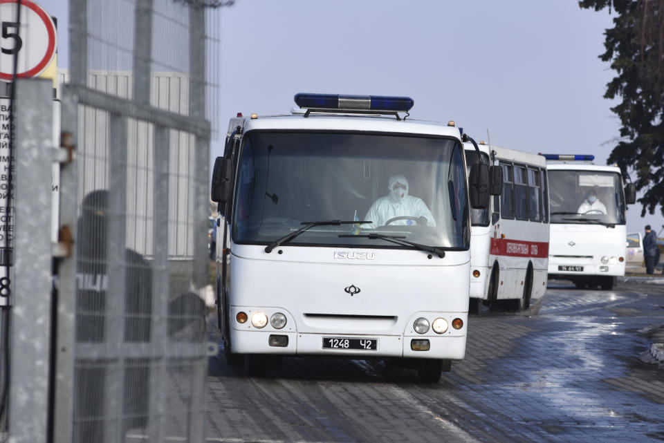 Busses with passengers from the Ukrainian aircraft chartered by the Ukrainian government for evacuation from the Chinese city of Wuhan, leave the the gate upon their landing at airport outside Kharkiv, Ukraine, Thursday, Feb. 20, 2020. Ukraine's effort to evacuate more than 70 people from China due to the outbreak of the new COVID-19 virus was delayed because of bad weather as evacuees travel to a hospital where they are expected to be quarantined. (AP Photo/Igor Chekachkov)