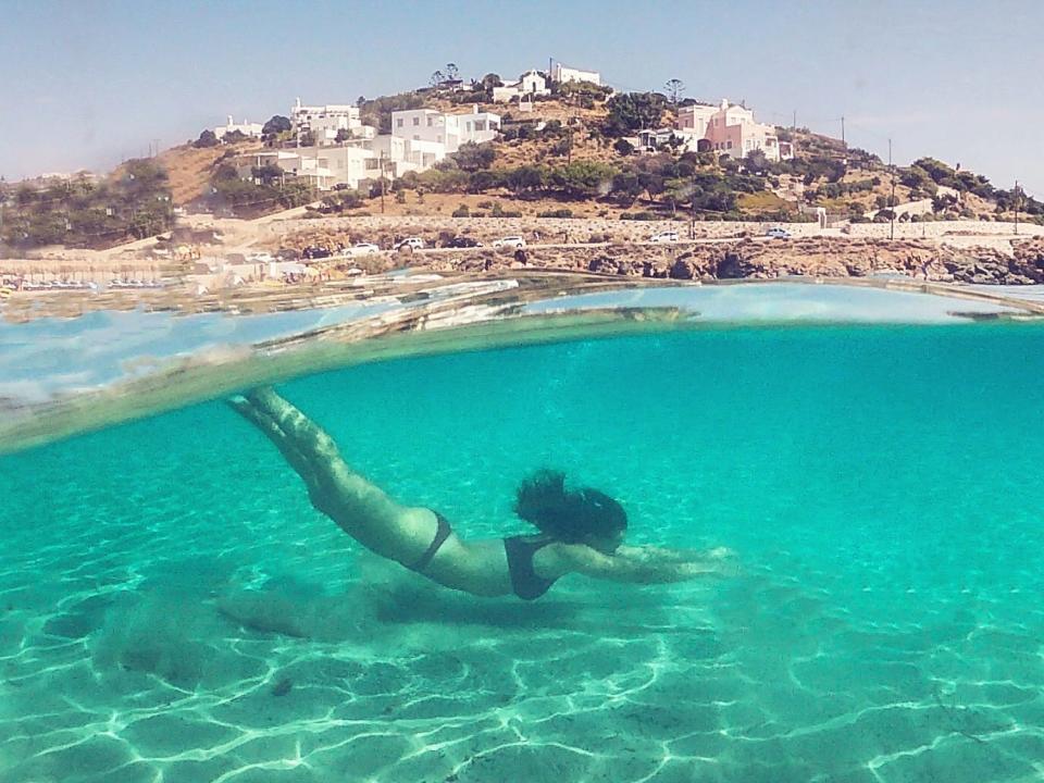 shot of a person swimming underwater at agathopes beach in syros greece