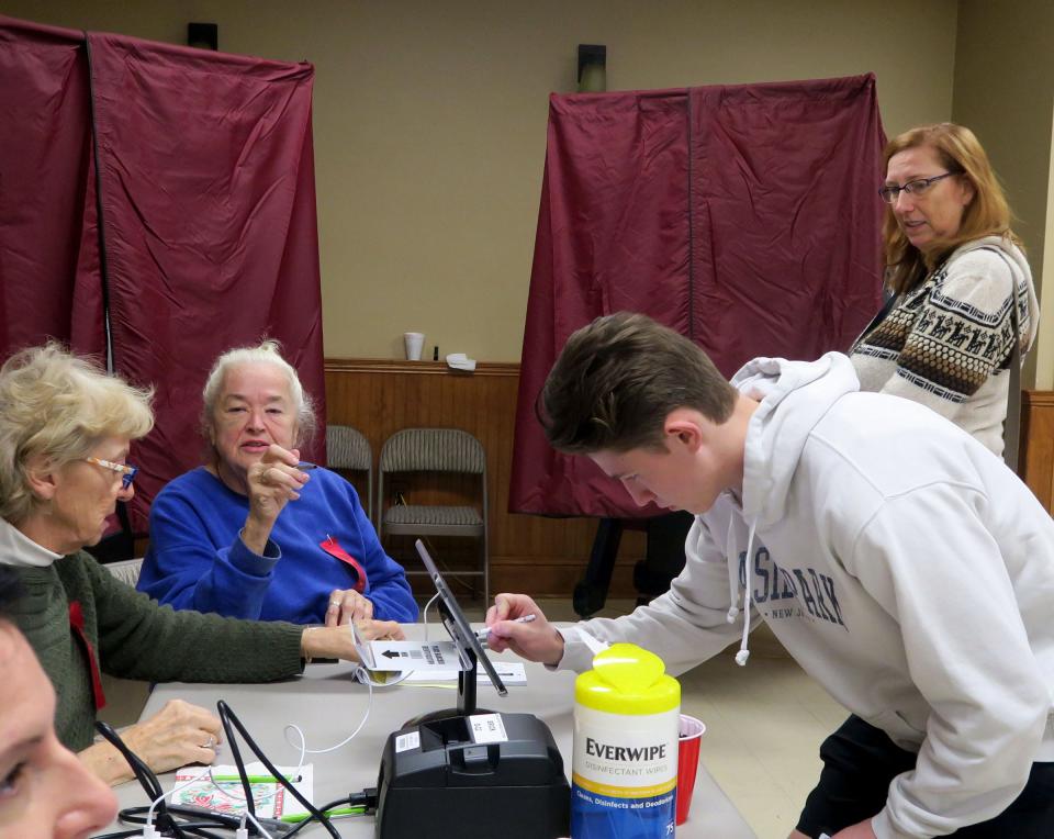 Sam Grenier, 18, signs in to cast his first vote at the Herbertsville Fire Company polling place in Brick Township Tuesday morning, November 2, 2021.