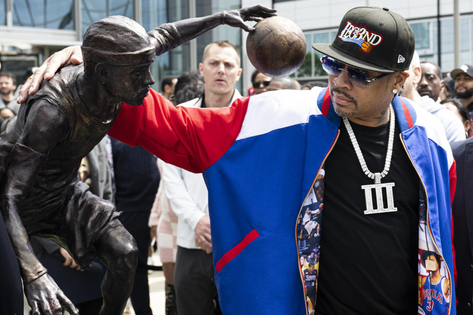 Former Philadelphia 76ers NBA basketball player Allen Iverson poses for photos next to his statue at the teams training center in Camden, N.J., Friday, April 12, 2024 (Jose F. Moreno/The Philadelphia Inquirer via AP)