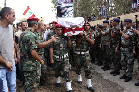 Lebanese Army soldiers and relatives of Alawite soldier Ali Khaddaaro carry his coffin during his funeral in Talhmera village, Akkar August 5, 2014. REUTERS/Stringer