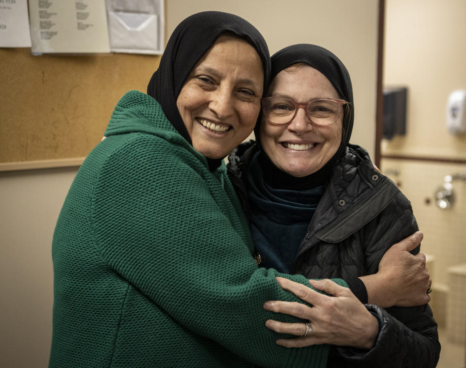 Bibi Bahrami and her close friend, Dr. Miriam Ibrahim, embrace each other at the Islamic Center of Muncie, Ind., on Friday, March 3, 2023. Bahrami is a subject of the documentary "Stranger at the Gate" that tells the story of the relationship she and others in their small Islamic community fostered with a former U.S. Marine who had planned to bomb their community center. (AP Photo/Doug McSchooler)