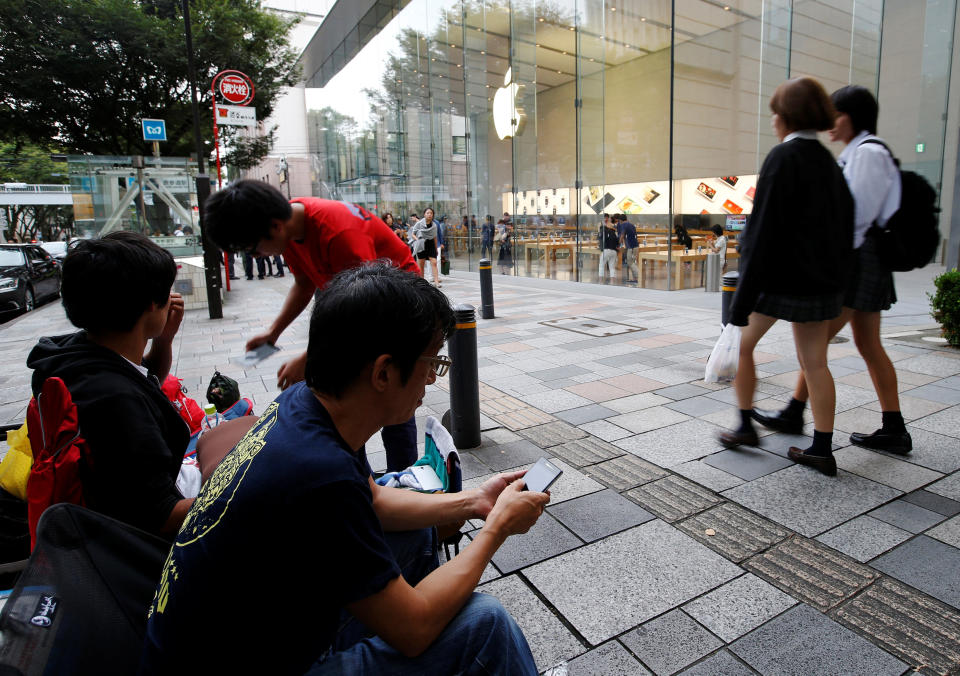 People sit in queue for the release of Apple's new iPhone 7 and 7 Plus in front of the Apple Store, in Tokyo's Omotesando shopping district, Japan September 15, 2016. REUTERS/Toru Hanai