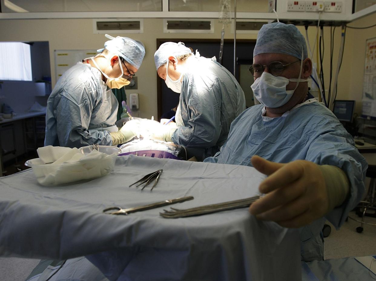 BIRMINGHAM, UNITED KINGDOM - JUNE 09: Consultant Surgeon Andrew Ready and his team conducts a live donor kidney transplant at The Queen Elizabeth Hospital Birmingham on June 9, 2006, in Birmingham, England. Kidney failure patient Carol Playfair was given the chance of life when her sister Tracey Playfair offered one of her own perfect kidneys to help save the life of Carol. The operation at The QE Hospital, part of The University Hospital's Trust was one of 1500 live donor transplants carried out in the United Kingdon every year. Despite the introduction of Donor Cards, there are still too few kidneys available to help all those who require a transplant, thereby producing a waiting list and the only chance of survival is by live donor. (Photo by Christopher Furlong/Getty Images)