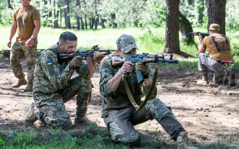 Two inmates receive training from the 59th brigade in a Ukrainian Woodland