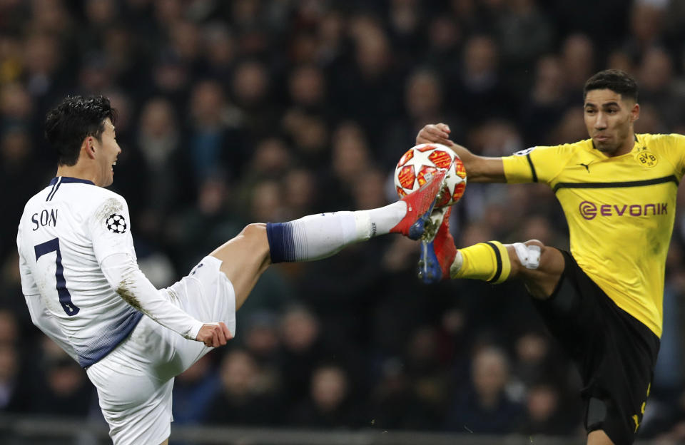 Tottenham midfielder Son Heung-min fights for the ball with Dortmund defender Achraf Hakimi, right, during the Champions League round of 16, first leg, soccer match between Tottenham Hotspur and Borussia Dortmund at Wembley stadium in London, Wednesday, Feb. 13, 2019. (AP Photo/Alastair Grant)