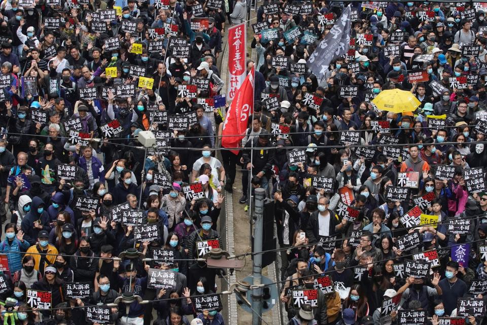 Hong Kong people participate in their annual pro-democracy march to insist their five demands be matched by the government in Hong Kong, Wednesday, Jan. 1, 2020. The five demands include democratic elections for Hong Kong's leader and legislature and a demand for a probe of police behavior during the six months of continuous protests. Placards read, " give demands, not one less"(AP Photo/Vincent Yu)