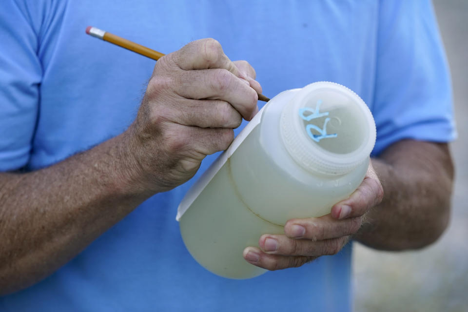 Des Moines Water Works employee Bill Blubaugh marks a water sample collected from the Raccoon River, Thursday, June 3, 2021, in Des Moines, Iowa. Each day the utility analyzes samples from the Raccoon River and others from the nearby Des Moines River as it works to deliver drinking water to more than 500,000 people in Iowa's capital city and its suburbs. (AP Photo/Charlie Neibergall)