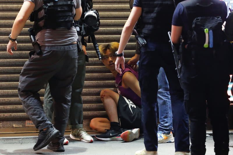 Riot police detain a man during a protest oppose postponed elections, in Hong Kong