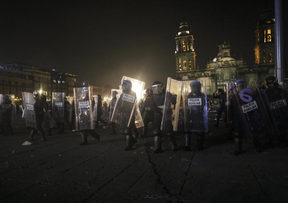 Riot police walk on Zocalo Square after a protest in support of 43 missing Ayotzinapa students in Mexico City