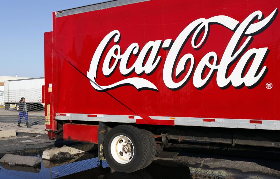 A woman walks past a Coca-Cola truck truck at a distribution center in Alexandria