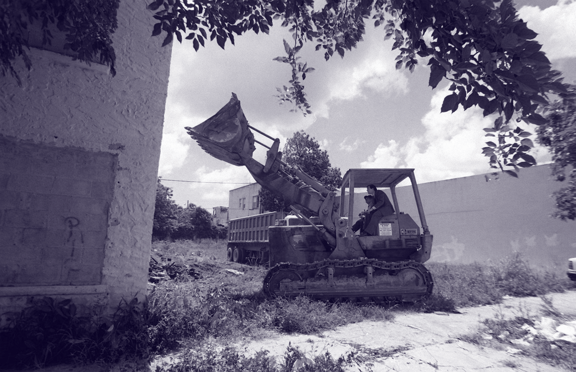 Carollo, then mayor, sits next to the operator of a bulldozer in 1997 as the city tears down an alleged crack house at 1421 NE Miami Ct.