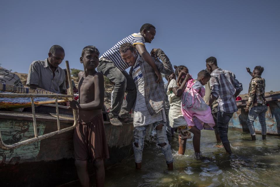 Tigray refugees who fled the conflict in the Ethiopia's Tigray arrive on the banks of the Tekeze River on the Sudan-Ethiopia border, in Hamdayet, eastern Sudan, Tuesday, Dec. 1, 2020. (AP Photo/Nariman El-Mofty)