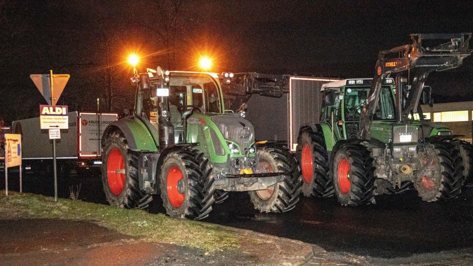 Traktoren stehen vor der Zufahrt zum Lager des Lebensmittel Discounters Aldi.