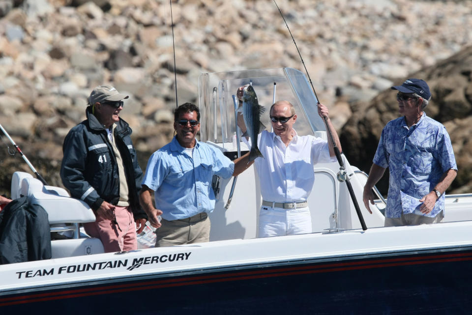 With former President George H.W. Bush and President George W. Bush looking on, Russia's President Vladimir Putin holds up his catch Monday, July 2, 2007, with the help of fishing guide Billy Bush, during a morning outing at Walker's Point in Kennebunkport, Maine. (Photo by Eric Draper/The White House/MCT/Sipa USA)