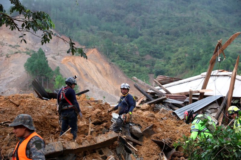 Rescue workers inspect an area hit by a mudslide, caused by heavy rains brought by Storm Eta, as the search for victims continue in the buried village of Queja