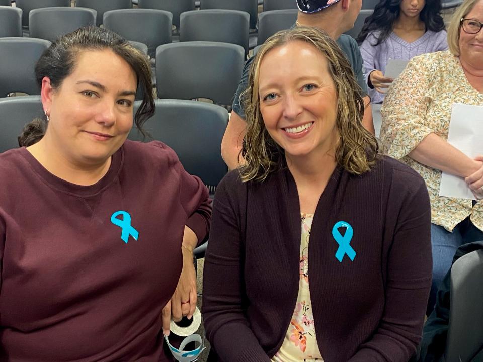 Porter Herring, left, and Jennifer Montgomery attended the Lake Travis school board meeting Wednesday to support Carter Mannon and his family. Their teal ribbons encourage awareness of food allergies.