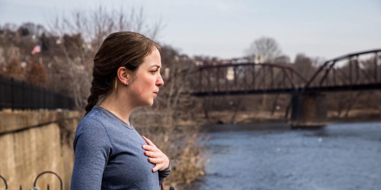 a runner taking a deep breath by a river