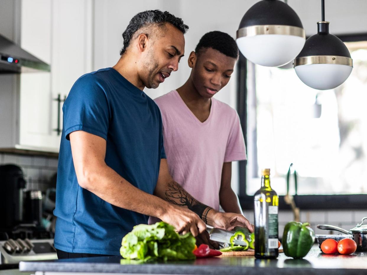 A father and son cooking a healthy dinner in the family kitchen