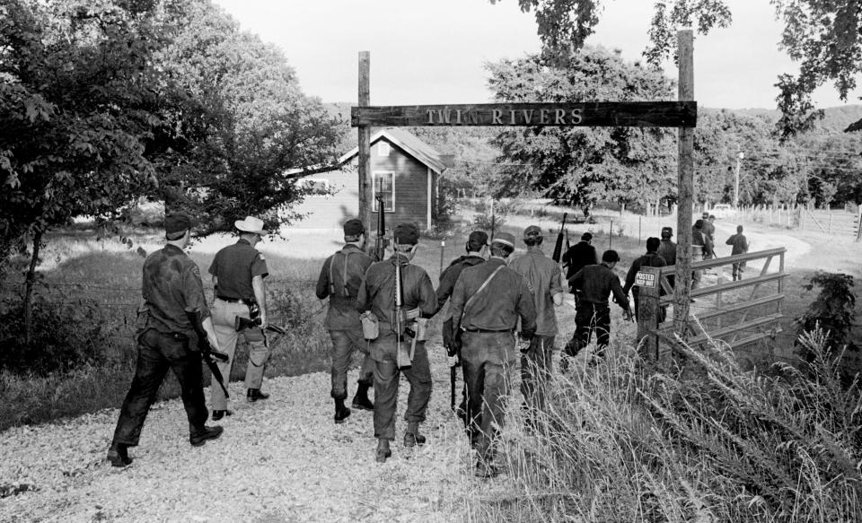 Officers enter private property near Locust Grove while searching for a suspect in the Camp Scott Girl Scout murders in June 1977. Staff Photo by Paul Southerland, The Oklahoman