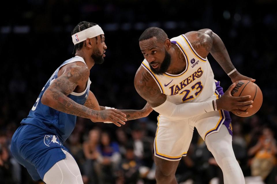 Los Angeles Lakers forward LeBron James (23) is defended by Minnesota Timberwolves guard Nickeil Alexander-Walker, left, during the first half of an NBA basketball game in Los Angeles, Sunday, March 10, 2024. (AP Photo/Eric Thayer)