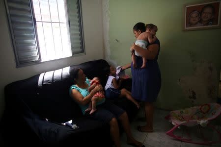 Jaqueline (R), 25, holds her five-month-old son Lucas while her mother Manyara (L), 46, holds her five-month-old granddaughter Laura at their house in Santos, Sao Paulo state, Brazil April 20, 2016. REUTERS/Nacho Doce