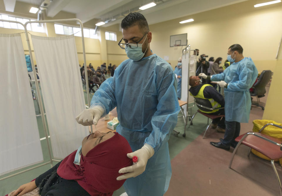 Health care workers take nasal swab samples from Palestinians at a COVID-19 testing center, in the Palestine Medical Complex, in the West Bank city of Ramallah, Tuesday, March 2, 2021. (AP Photo/Nasser Nasser)