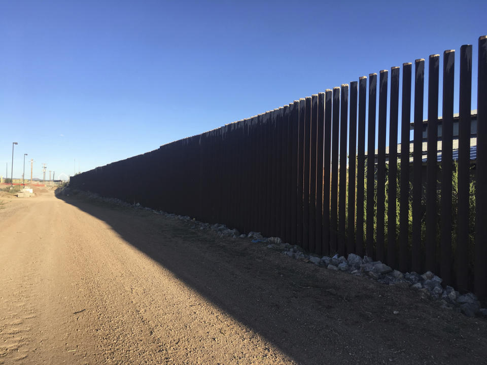 FILE - In this Oct. 3, 2018, file photo, a border fence in Columbus, N.M., sits along the U.S.-Mexico border at sunset. Residents of this tiny, historic border village are raising concerns about new trailers in the town center meant to house workers building the U.S.-Mexico border wall despite worries over COVID-19. (AP Photo/Russell Contreras, File)