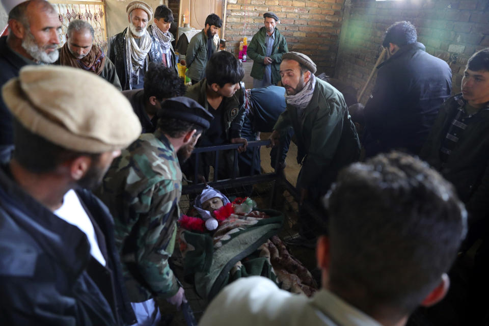 Relatives stand around the dead body of a boy who was killed by a mortar shell attack in Kabul, Afghanistan, Saturday, Nov. 21, 2020. Mortar shells slammed into different parts of the Afghan capital on Saturday. (AP Photo/Rahmat Gul)