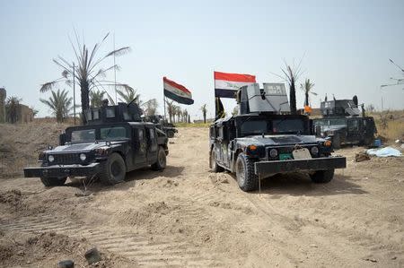 Iraqi security forces vehicles drive through Shuhadaa neighborhood in Falluja, Iraq, in this picture taken June 5, 2016. REUTERS/Stringer