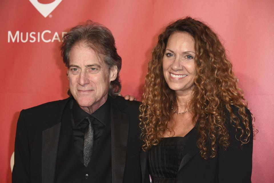 FILE - Comedian Richard Lewis, left, and Joyce Lapinsky arrive at the 2015 MusiCares Person of the Year event in Los Angeles on Feb. 6, 2015. Lewis, an acclaimed comedian known for exploring his neuroses in frantic, stream-of-consciousness diatribes while dressed in all-black, leading to his nickname “The Prince of Pain,” has died. He was 76. He died at his home in Los Angeles on Tuesday night after suffering a heart attack, according to his publicist Jeff Abraham. (Photo by Richard Shotwell/Invision/AP, File)