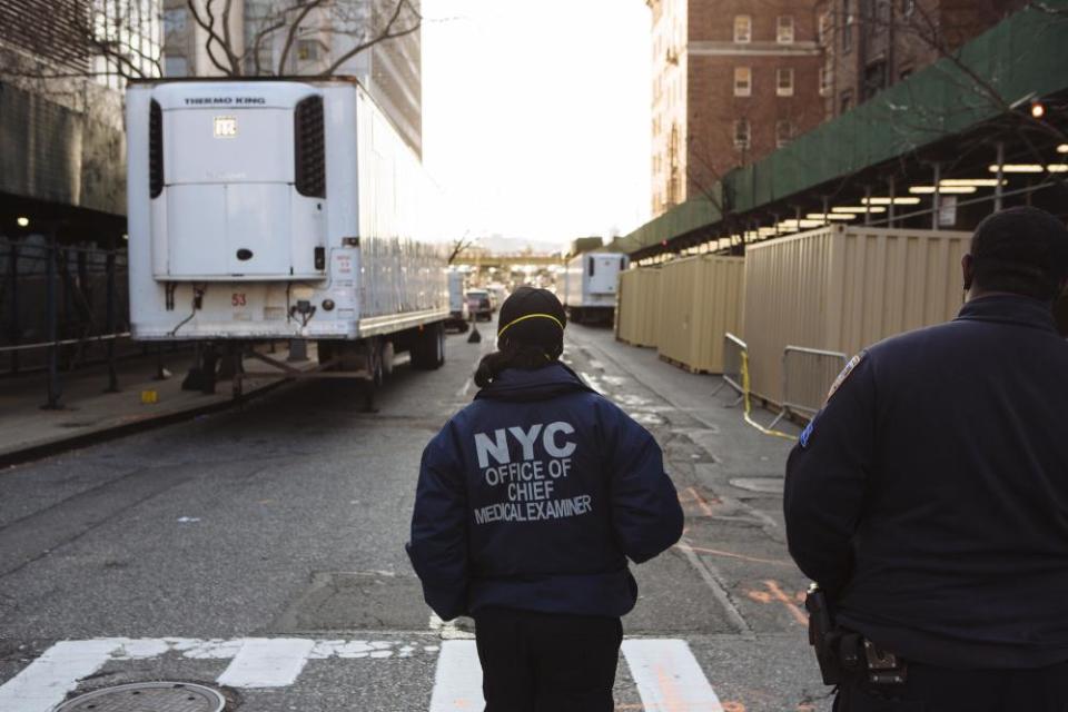 A worker from the Office of Chief Medical Examiner stands in front of a refrigeration truck outside Bellevue Hospital in New York.