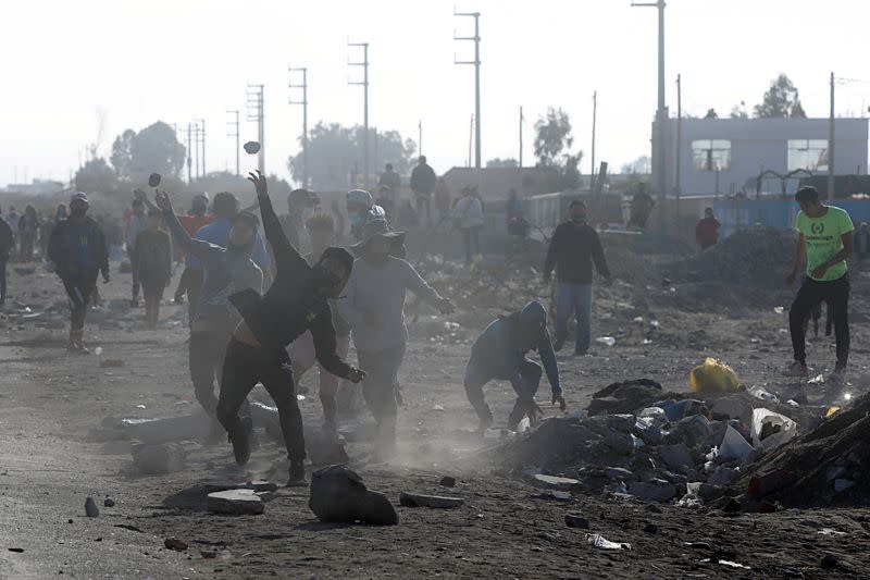 Drivers throw stones toward agricultural workers blocking the highway, in Villacuri