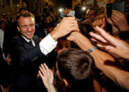 FILE PHOTO: French President Emmanuel Macron greets well-wishers as he arrives in Arles, France, July 19, 2017. REUTERS/Jean-Paul Pelissier/File Photo